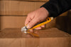 Close-up of SK-9 Semi-Auto Self-Retracting Safety Knife with Multi-Pick in action opening a cardboard box