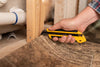Close-up of OLFA 25mm XH-AL Fiberglass Rubber-Grip Auto-Lock Utility Knife cutting linoleum flooring