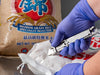OLFA SK-14 Semi-Automatic Stainless Steel Self-Retracting Safety Knife cutting bagged goods in industrial food setting