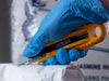 OLFA SK-4 Semi-Automatic Self-Retracting Safety Knife in use cutting a bag open